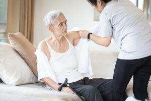 occupational therapist helping patient to get dressed